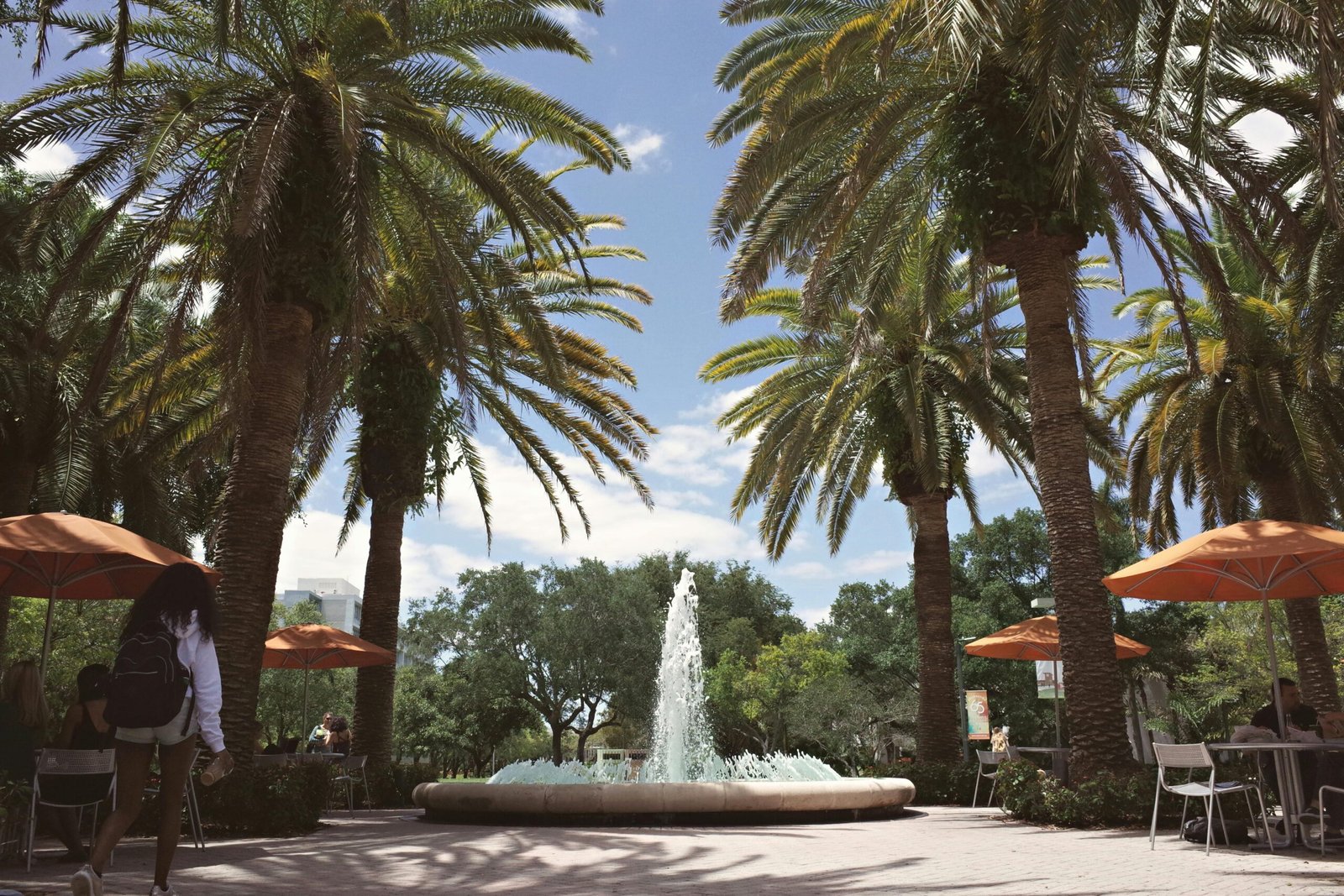 A vibrant university campus featuring palm trees and a central fountain in Coral Gables, Florida.