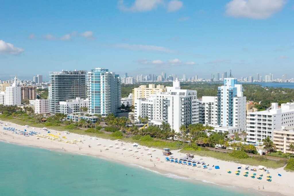 Stunning aerial shot of Miami Beach skyline with bright blue skies and sandy coastlines.